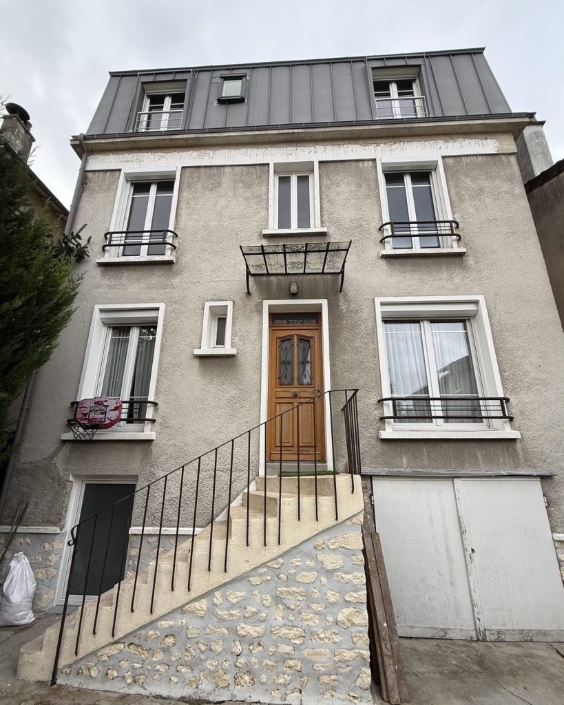 Façade de maison de ville au crépi gris encrassé et fissuré, avant isolation thermique par l extérieur
